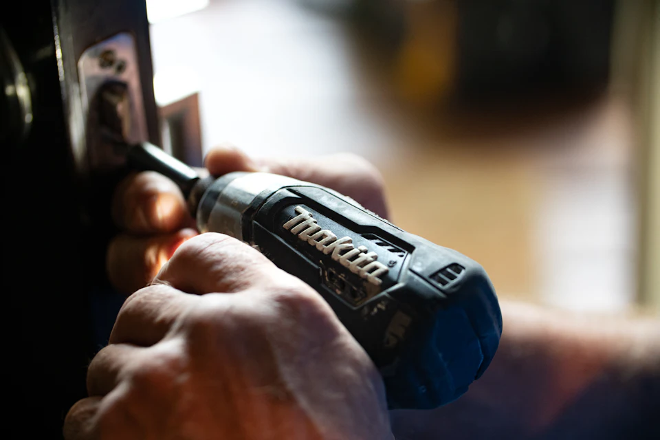 Handyman driving an anchor into a wall with a cordless drill