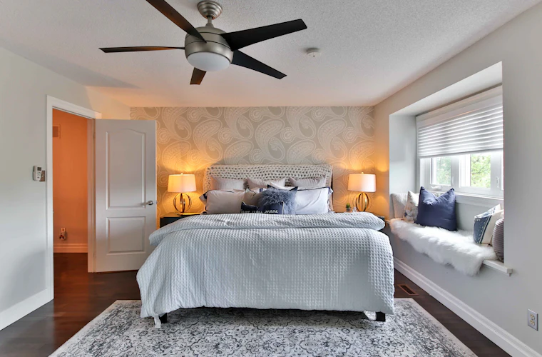 Ceiling fan installed and running above a finished bedroom